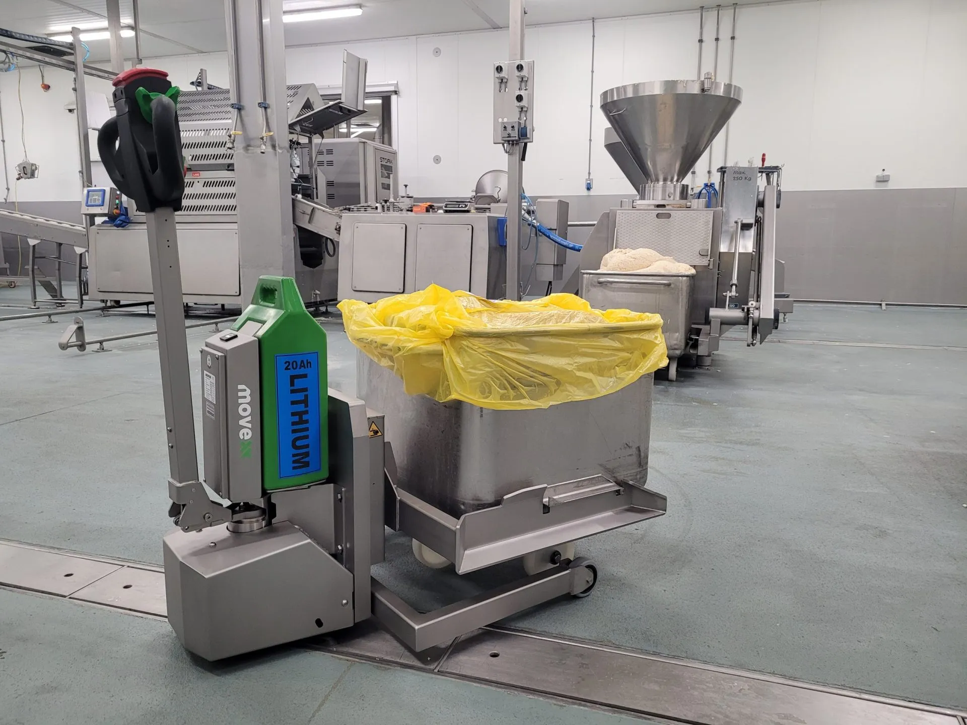 Electric tug moving a waste bin inside a facility