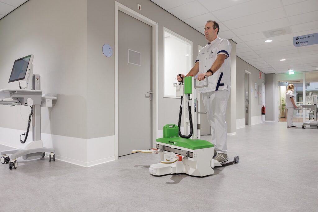 MOVEXX TT0450-M-BM bed mover moving an occupied patient bed along a hospital corridor at Amphia hospital