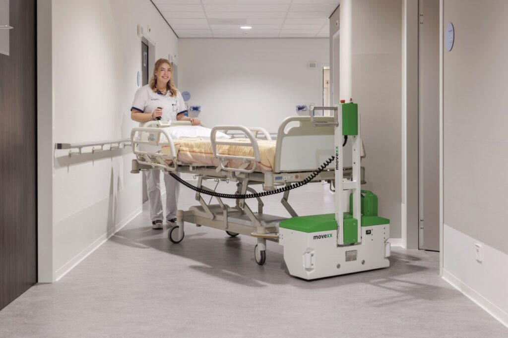 MOVEXX TT0450-M-BM bed mover coupled to a patient bed on a hospital ward