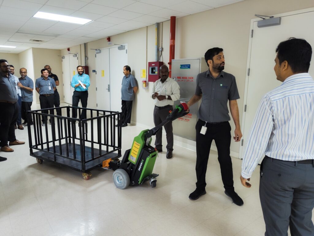 MOVEXX TT1500-T electric tug towing a loaded supply cage at a private hospital in Dubai while the hospital team watches